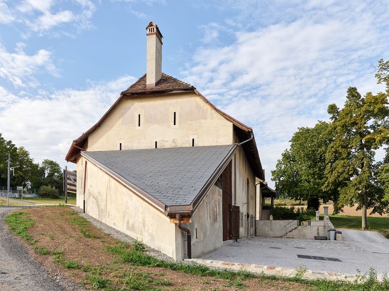 Hauteville, du château au campus, histoire d'une reconversion – Grange avec tuiles photovoltaïques, cheminée du CAD à bois, bornes de recharge – Luca Delachaux, atelier delachaux photographie / Pepperdine University